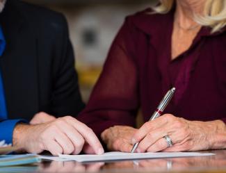 An older couple signing documents